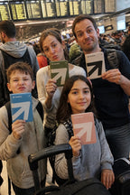 Family at airport check-in, each with their own colour passport holder
